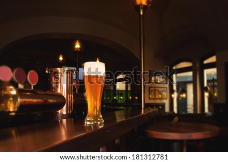 Glass of lager beer on bar of restaurant