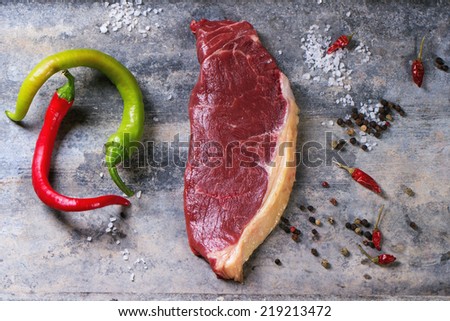 Raw steak with hot peppers over tin surface. See series
