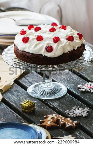 Christmas table setting with chocolate cherry cake and sugar cookies. See series