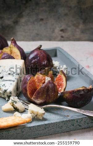 Figs with blue cheese, white wine and crackers on wooden tray. See series.