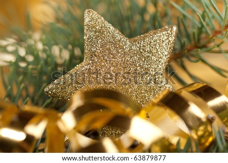 Golden christmas star and tape with christmas tree on the gold background