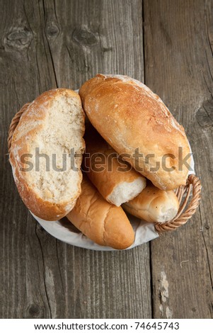 Top view on fresh bread in basket on old wooden table