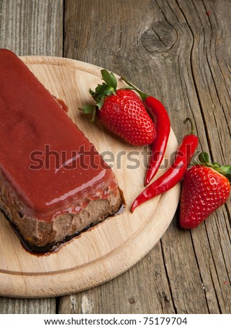 Pate Appetizer with strawberry jelly, fresh strawberry and red hot chili peppers on wooden desk over wooden background