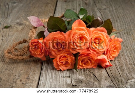 Bunch of orange roses on old wooden table