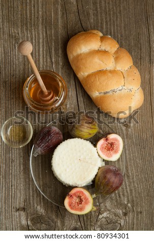 Top view on Plate with white cheese and fresh figs with honey and bread on old wooden table