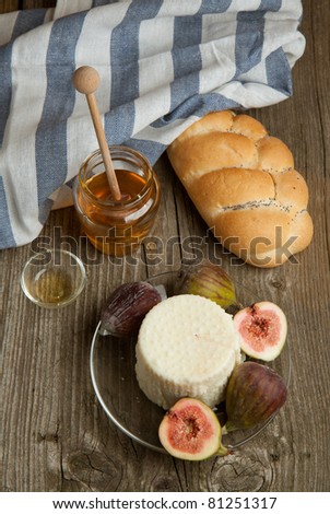 Top view on plate with white cheese and fresh figs with honey and bread on old wooden table