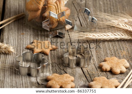 Homemade sugar cookies with metal cookie cutters and rye on old wooden table