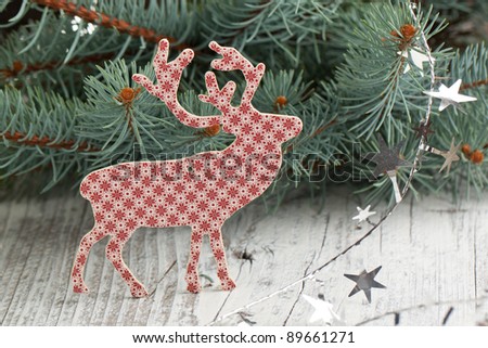 Christmas deer near christmas tree on white wooden table