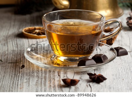 Cup of hot tea with dark chocolate on old wooden table