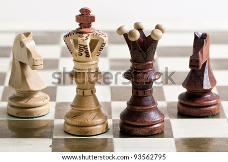 Black and white chess figures on chess desk