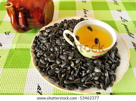 Image of sunflower seeds on a saucer with a cup of sunflower oil