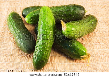 image of green, fresh, ripe cucumbers on jute napkin