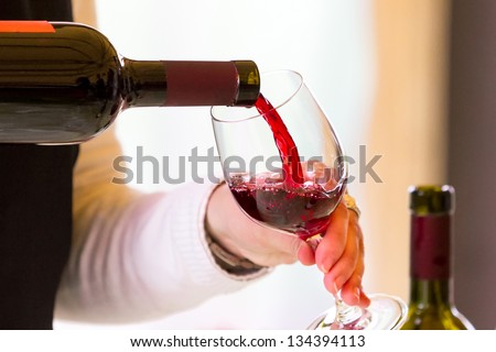 Waiter pouring  red wine