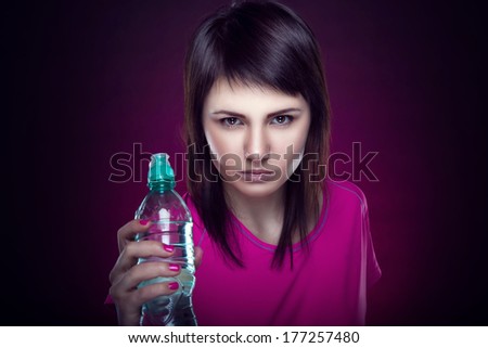 Beautiful girl with a bottle of water in hand. Taking part in sports. Healthy lifestyle. Healthy food