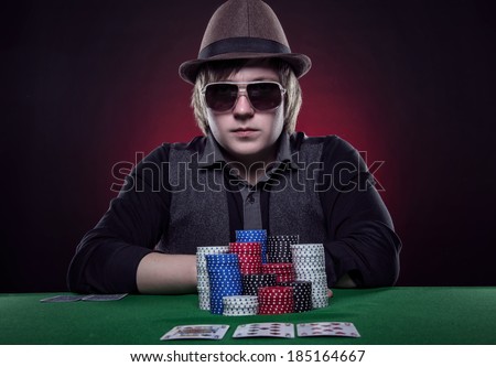 Beautiful young man on a beautiful background playing poker. Good luck in card games on the big money