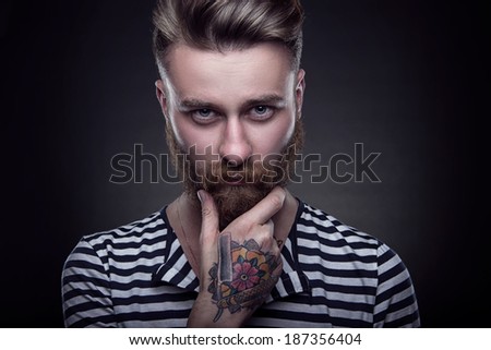 Handsome stylish young man. Brutal man with a beard and tattoo