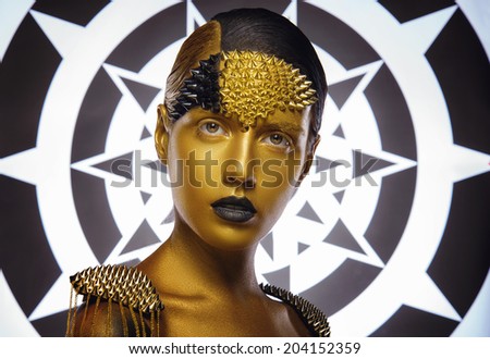 Beautiful young woman with gold makeup. Face art. Beautiful background
