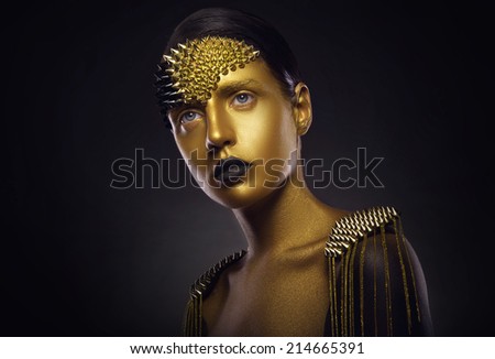 Beautiful young woman with gold makeup. Face art