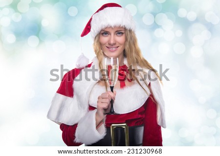 Beautiful young girl in a Christmas costume. New Year's holidays. Woman celebrating Christmas. Girl with a glass of champagne