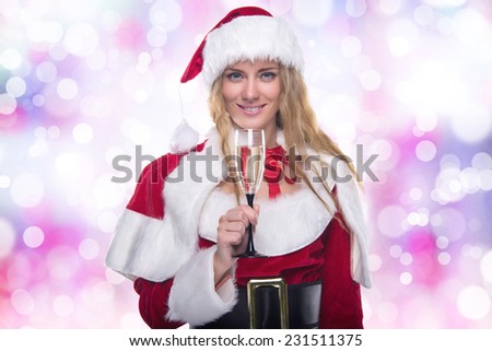 Beautiful young girl in a Christmas costume. New Year\'s holidays. Woman celebrating Christmas. Girl with a glass of champagne