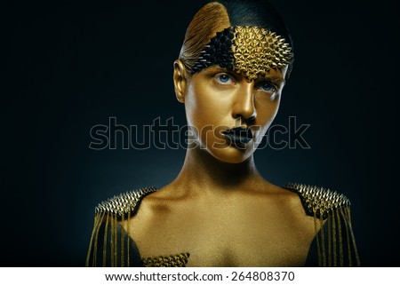 Beautiful young woman with gold makeup. Face art. looking at the camera