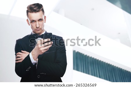 Handsome young man in a tuxedo looking at the camera. Fashionable Clothing. Clothing for the festive evening. Elegant man calling on the phone