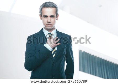 A handsome man in a jacket and tie for business negotiations. Looking at the camera. Office worker. Business decisions. Beautiful light background