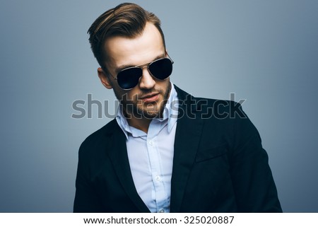 Handsome stylish young man. Brutal man with a beard and sunglasses