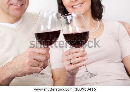 Mature couple drinking red wine at home