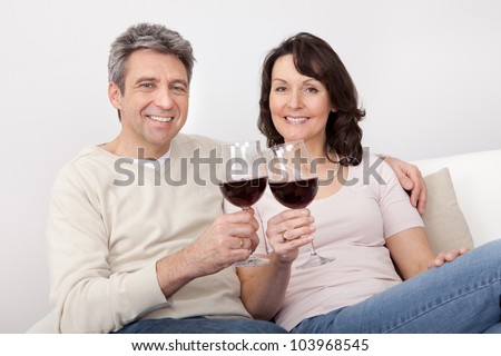 Mature couple drinking red wine at home