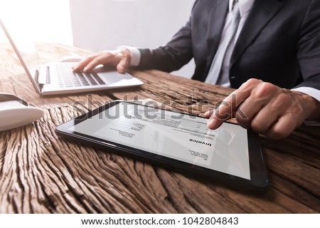 Close-up Of A Businessman\'s Hand Working With Invoice On Digital Tablet