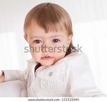 Portrait of a cute innocent young baby smiling and looking with love