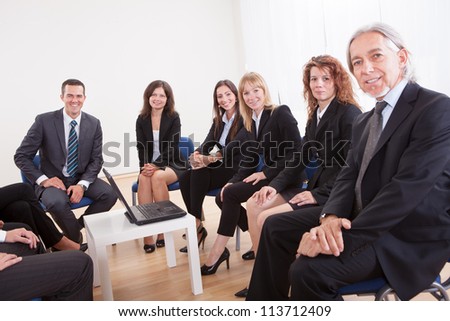 Group Of Business People Sitting On Chair Attending The Meeting