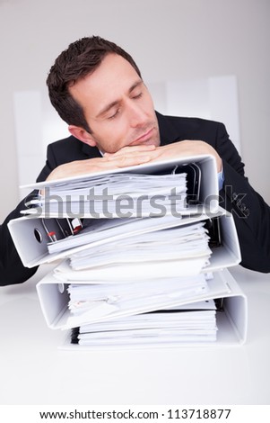 Bored Businessman Overwhelmed By Paperwork In The Office