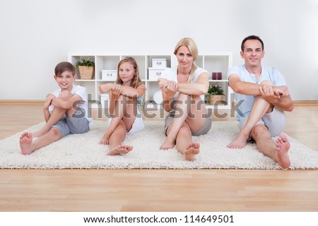 Family Doing Stretching Exercises Laying On The Carpet At Home