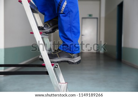 Low Section View Of A Handyman\'s Foot Climbing Ladder