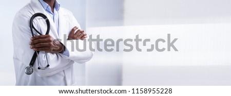 Panoramic View Of Male Doctor With Arms Crossed Holding Stethoscope