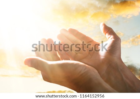 Close-up Of A Person Raising His Hand Up To The Sky In Sunlight