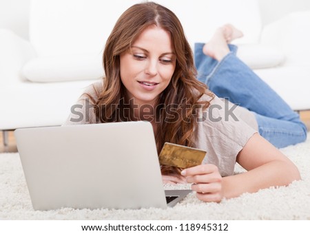 Young beautiful woman shopping using laptop at home
