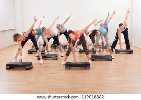 Diverse group of people in a class doing aerobics balancing on boards exerting control over their muscles and breathing