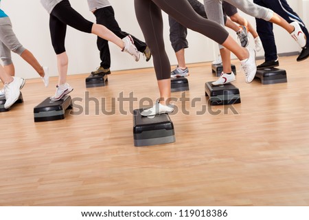 Diverse group of people in a class doing aerobics balancing on boards exerting control over their muscles and breathing