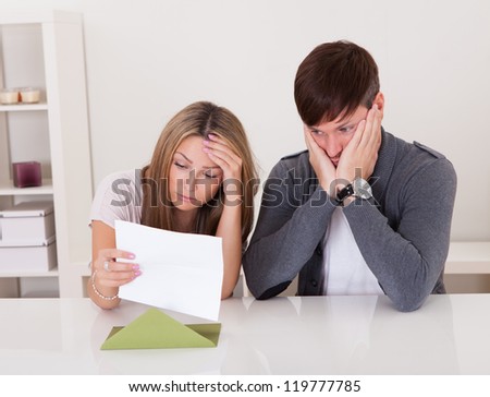 Shock portrayed on man's face after reading letter.