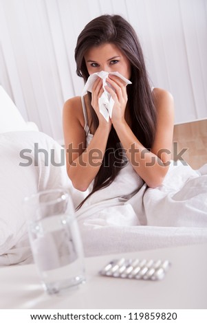 Woman ill in bed with a seasonal cold and flu