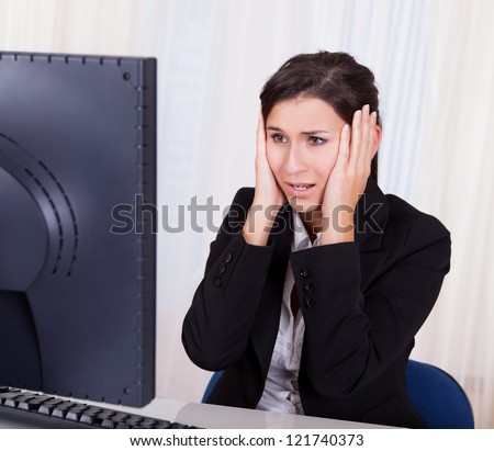 Studio shot of a frustrated businesswoman looking at her computer screen in dismay