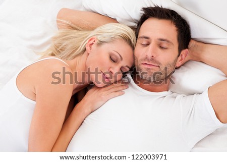 Beautiful young couple relaxing in bed at home