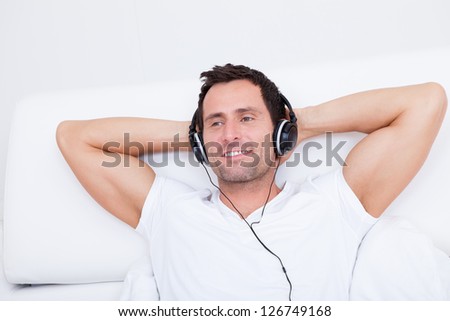 Young Man Listening Music On Headphone, Indoors