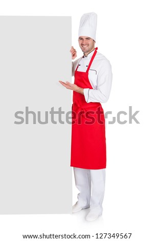Portrait of chef in uniform presenting empty banner. Isolated on white