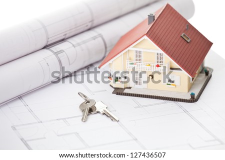 Model home and house key on architectural floor plans
