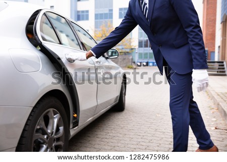 Valet\'s Hand Opening Grey Car Door On Street