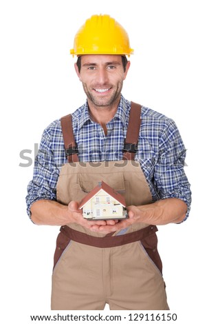 Construction worker presenting house model. Isolated on white